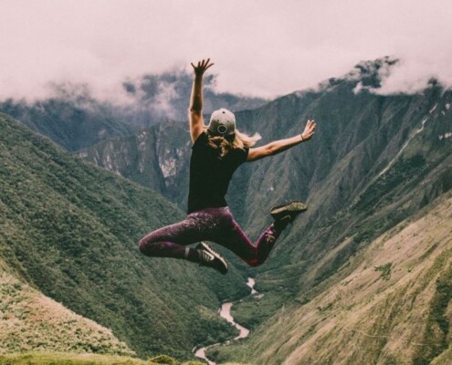 Woman in a mountainous canyon jumping for joy