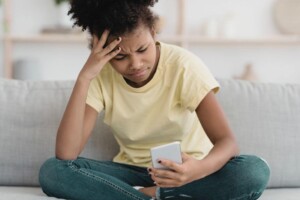 Anxious teen reading social media on mobile phone