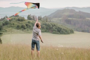 Young girl flying a kite in an open field