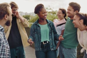 A group of diverse friends laughing together. Therapy for young adults in Cherry Hill, NJ is here to support your through difficult decisions. Reach out now to get started.