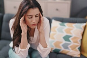 A mother sits on a couch with her eyes closed, holding her head in overwhelm. A postpartum depression therapist in Medford, NJ can help you tackle stress & anxiety. Learn more by exploring our blog.
