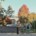 Students walk through a tree-lined campus with fall foliage.