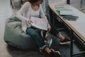 A teen student putting away their notebooks into a backpack. Our teen therapy in Medford, NJ is here to support your teen with school anxiety, stress & more. Reach out today to get started. 