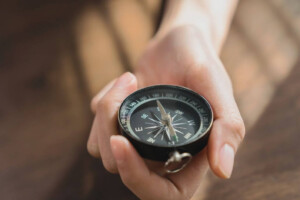Close-up of a hand adjusting a compass. 