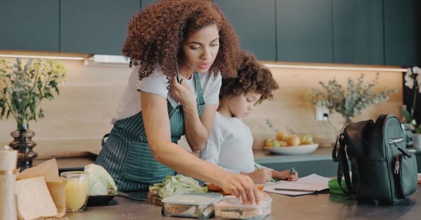 A mom multitasking during the morning routine with child.