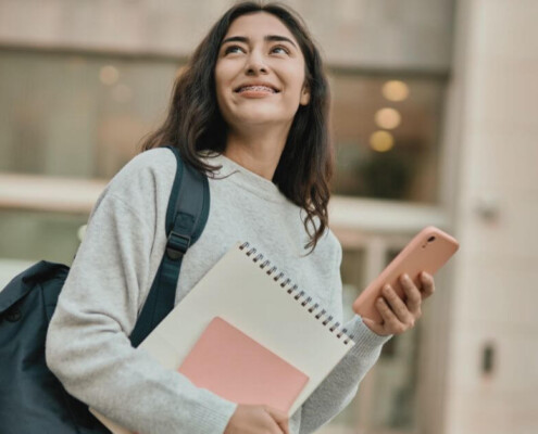 A student walks through campus with a heavy backpack.
