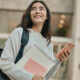 A student walks through campus with a heavy backpack.