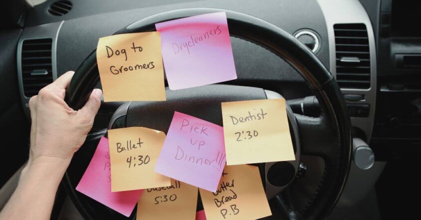 Sticky notes with reminders covering a car steering wheel.