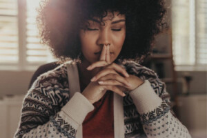 A woman sitting with eyes closed in quiet reflection