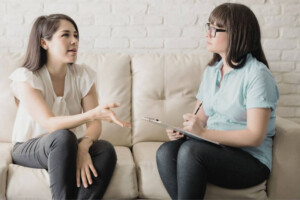 Woman talking to therapist on a couch.