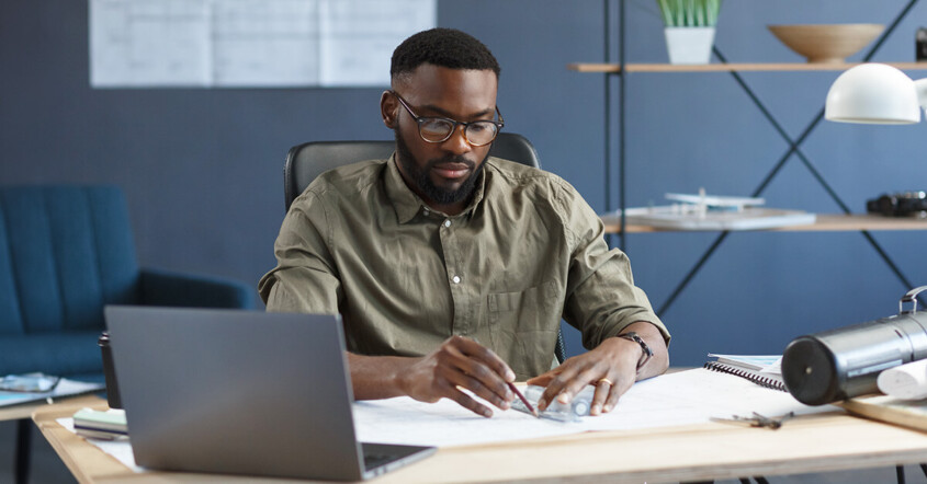 Architect in an empty office staying late at work again.