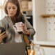 Working woman looking concerned at her phone while holding a coffee mug. Workplace stress & anxiety can increase burnout in women. Discover how women's counseling in Medford, NJ can help you find stress relief strategies.