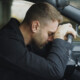 Stressed man resting his head against a steering wheel in car. This represents how stress & anxiety can affect men differently. Learn how men's counseling in Medford, NJ can help you.