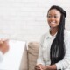 A Black woman sitting on a couch smiling at a therapist taking notes. To get paired with the right therapist, schedule a call with Mindful Soul. Our women's therapists in Medford, NJ are here to support you.
