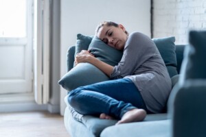 woman on couch | medford therapist | therapy in medford, nj | virtual therapy new jersey | medford therapy | medford, nj | haddonfield, nj | cherry hill, nj Woman lying on couch blue couch pillows. If you are struggling with trauma, anxiety, or other life challenges, therapy in Medford, NJ can help. Reach out today to Mindful Soul.